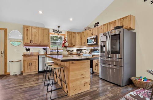 Galax House | A secluded, multi-level log cabin featuring a spacious wooden deck, open-concept living, a fully equipped modern kitchen, and comfortable sports-themed bunk rooms.
