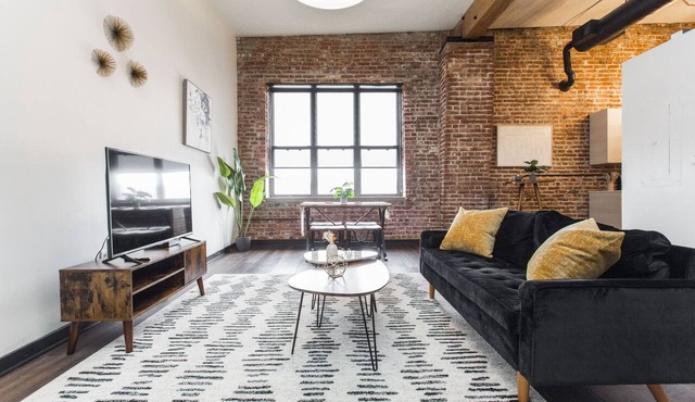Exposed brick, wood beams, & chic touches give this loft serious style. Enjoy skyline views from the rooftop, a full kitchen with coffee bar, king bed, on-site gym, & quick access to the free KC streetcar. Walk to shops/dining, and the City Market!